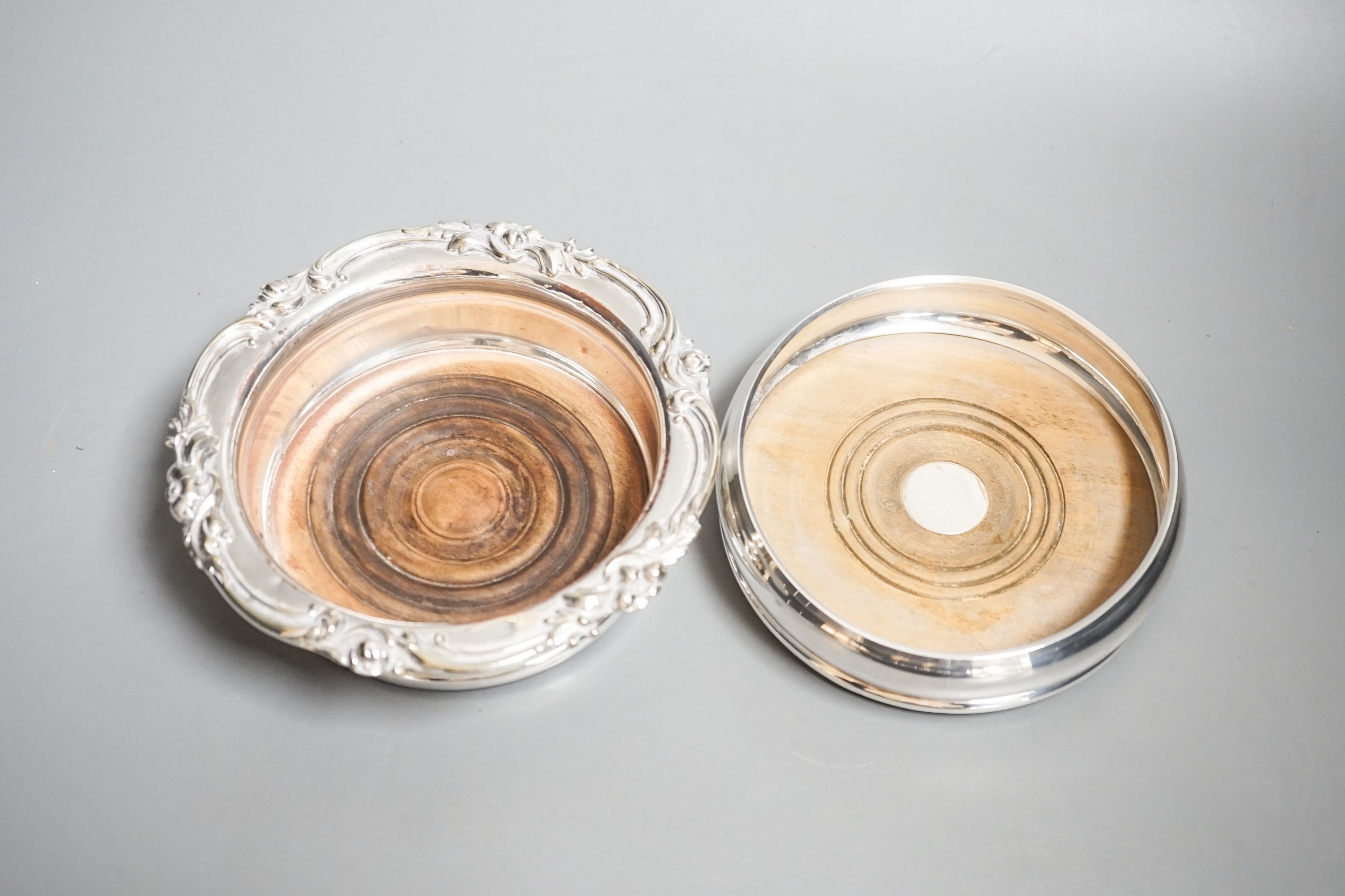 A modern silver mounted wine coaster, 12.2cm and a silver plated wine coaster.